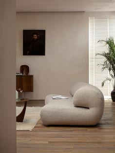 a living room with a couch, table and potted plant