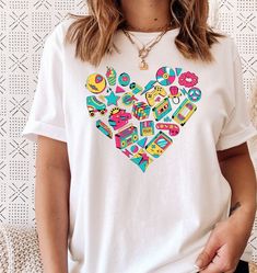 .:Description:. This 80's or 90's nostalgia, vibe heart retro graphic tee is a perfect gift for your favorite millennial, 1980's baby, 1990's baby or to add to your own collection. If you need an 80's or 90s theme party outfit, this t-shirt is perfect! Unisex, light weight, loose fit, soft material and high quality t-shirt. Sleeves are rolled for styling purposes. .:This is a direct to garment item meaning a high quality, water soluble ink is used. The ink is stretchy, durable and can be washed 90s Theme Party Outfit, I Love The 90s, Heart Retro, 90s Theme Party, Love The 90s, Trendy Tees, Peoria Az, 90s Theme, 90s Party