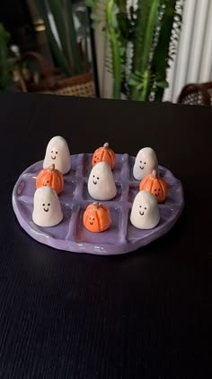 there are many small plastic pumpkins in the shape of ghost faces on an ice tray