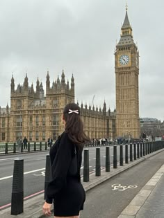 a woman walking down the street in front of big ben