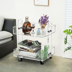 a living room with a couch, table and two shelves on wheels that hold magazines