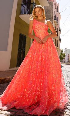 a woman in an orange dress standing on a brick walkway with her hands on her hips