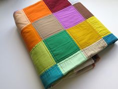 a multicolored patchwork quilt on top of a white table