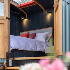 a bed in the back of a truck with flowers on the floor and windows above it