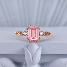 an engagement ring with a pink tourmaline surrounded by diamonds