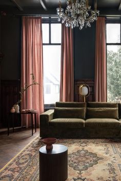 a living room with two couches and a chandelier