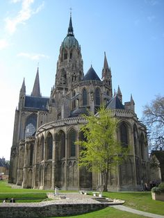 the large cathedral has many spires on it's sides and is surrounded by green grass