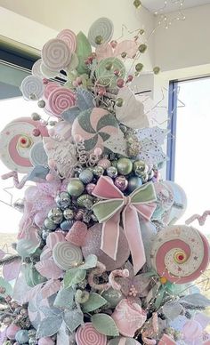 a pink and green christmas tree decorated with lollipops