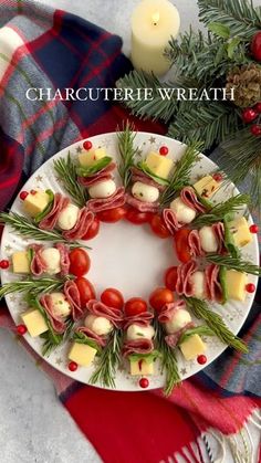 a white plate topped with food on top of a red and blue table cloth next to a candle