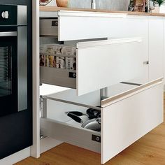 an open drawer in the middle of a kitchen