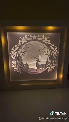 an illuminated shadow box with a deer in the middle