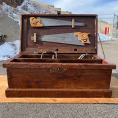 an old wooden box with two knives in it