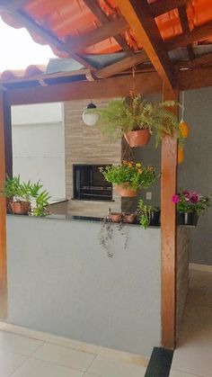 an outdoor kitchen with potted plants on the counter