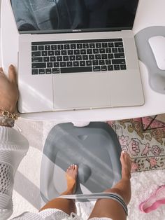 a person sitting at a table with their feet on a glass plate in front of a laptop