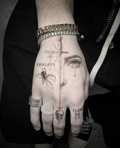 a person's hand with tattoos on it and a spider crawling out of the palm