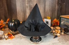 This low profile petite style witch hat is made of a black colored, eco-friendly felt. It has a black velvet band and a matching detachable black bow. Options to add a splash of color to match your witchy apparel. Its circular brim is narrow and the pointy cone is much shorter than your average witch hat, giving it a unique appeal. It's not an "in your face" hat. Inspired by the ancestors who hid in plain sight it's an ode to a classic style hat.  It offers a cottage core vibe and would be a gre Black Witchy Hat With Curved Brim, Black Hat For Costume Party In Fall, Witchy Black Costume Hats And Headpieces For Fall, Black Witchy Hat For Halloween, Witchy Black Costume Hat For Fall, Black Brimmed Halloween Hat, Black Brimmed Witchy Hat, Black Brimmed Hat For Halloween, Black Witchy Brimmed Hat