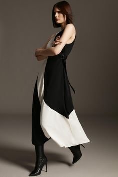 The Classic Color Block Is Tailored With Runway Appeal To Form This Statement Midi Dress. Crafted From Soft Jersey That Drapes The Frame With Luxe Appeal, It Has A High Neckline That Flows Into A Flared Skirt - Structured With An Exposed Back And Elasticated Rear Waist That Nips The Shape For An Hourglass Effect. Offset With Two D-Ring Side Adjusters For A Flexible Fit, Pull This Piece Close To Create A Form-Fitting Look Or Let It Flow With Languid Ease. Modern Fitted Maxi Dress For Work, Modern Sleeveless Maxi Dress For Work, Chic Asymmetrical Maxi Dress For Work, Elegant Fitted Dresses With Contrast Color, Chic Color Block Maxi Dress For Party, Chic Spring Dresses With Contrast Color, Chic Color Block Maxi Dress, Elegant Color Block Party Dress, Elegant Spring Maxi Dress With Color Block