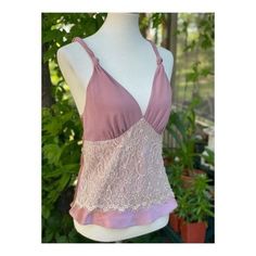 "Approx flat lay measurements Chest 16\" Length 23.5\" Size small on tag. 100% polyester. Made in China. Stunning satin camisole in a dusty rose colour way. A lace panel decorates across the abdomen, v neckline, straps feature a twisted knot design. No closures, it is pull on. No holes, tears or stains, pet snd smoke free home." Feminine Bra-friendly Tank Top, Pink Lace Top Camisole, Pink Fitted Lace Top Camisole, Fitted Lace Top Pink Camisole, Fitted Pink Camisole With Lace Top, Pink V-neck Top With Adjustable Straps, Pink Feminine Tank Top With Lace Trim, Feminine Pink Tank Top With Lace Trim, Chic Pink Lace Trim Camisole