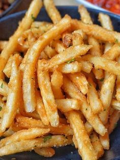 french fries on a blue plate next to other foods