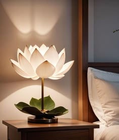 a large white flower sitting on top of a wooden table next to a night stand