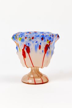 a colorful glass bowl sitting on top of a white table