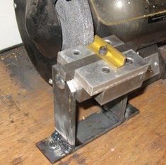 a metal object sitting on top of a wooden floor next to a machine tool holder