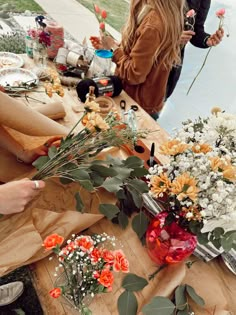 people standing around a table with flowers on it