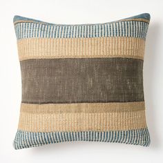 a brown and blue striped pillow sitting on top of a white wall