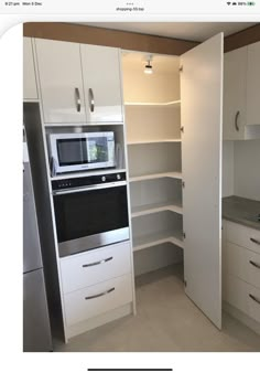 a kitchen with an oven, microwave and cupboards in the corner next to each other