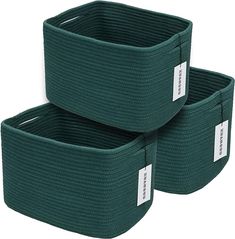 two green storage baskets with labels on them are sitting side by side in front of each other