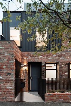 a brick building with a black gate and metal railings on the front entrance to it