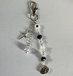 a key chain with dices and charms hanging from it's side on a white surface