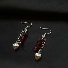 earrings with garnet stone, chains and heart lockets. colour palette: black, white, dark red.