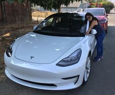 a woman leaning on the hood of a white car