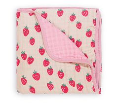 a pink blanket with strawberries on it and a pink pillow under the cover is folded