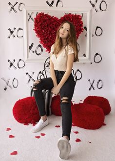 a woman sitting on the floor in front of a heart