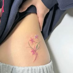 a woman's thigh with a flower tattoo on her lower leg and the bottom part of her stomach