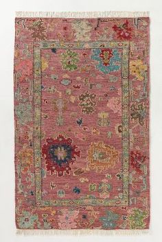 an old rug with many different colors and designs on the carpet, including pinks