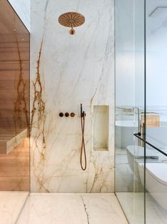 a bathroom with marble walls and flooring next to a walk - in shower area