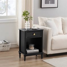 a living room with a white couch and black end table