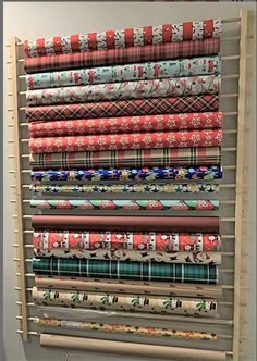 a wooden rack holding many different types of wrapping paper