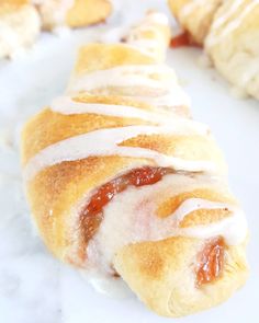 a pastry with white icing on it sitting next to other pastries