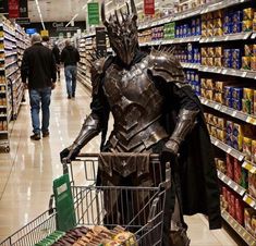 a man dressed as darth vader shopping in a grocery store with his cart full of food