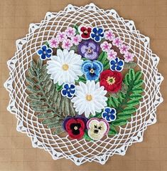 a white doily with flowers and leaves on it