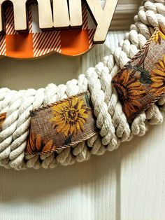 a close up of a rope with flowers on it and the word vinyl spelled in wood letters