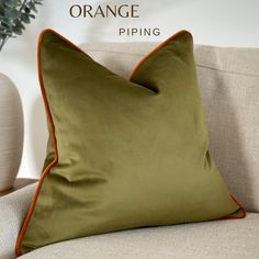 an orange piping pillow sitting on top of a couch