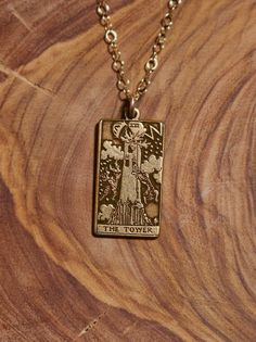 a gold necklace with an image of the virgin mary and jesus on it is sitting on a wooden surface