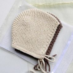 a knitted beanie hat on top of a clear plastic bag with the word pattern written across it