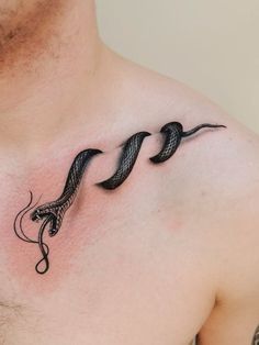 a man with a tattoo on his chest has two snakes in the shape of hearts