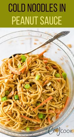 a glass bowl filled with noodles and carrots